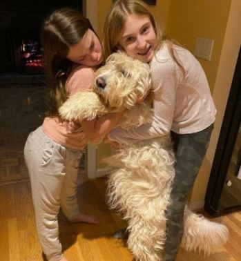 Heather Orne and Neil Orne children hugging their dog.